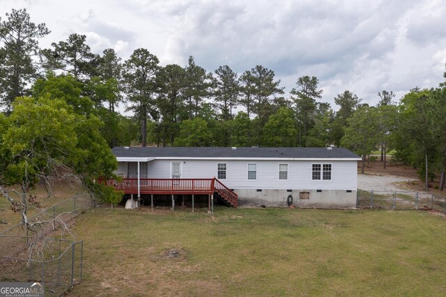back of house featuring a deck, a lawn, a fenced backyard, and stairs