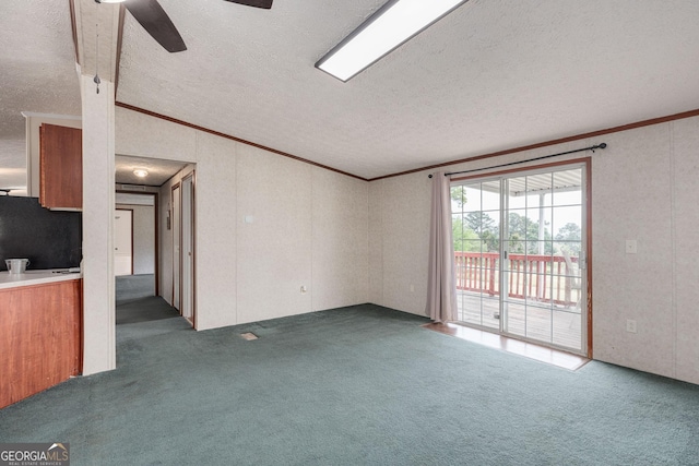 unfurnished living room featuring ceiling fan, a textured ceiling, carpet floors, and ornamental molding