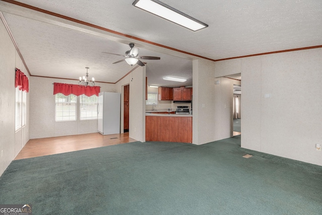 unfurnished living room with light carpet, ornamental molding, a textured ceiling, and ceiling fan with notable chandelier