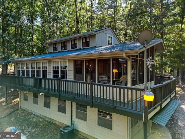 rear view of property featuring cooling unit and metal roof