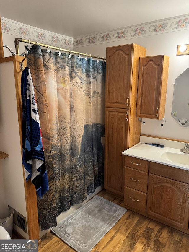 full bathroom featuring wood finished floors, vanity, and a shower with curtain