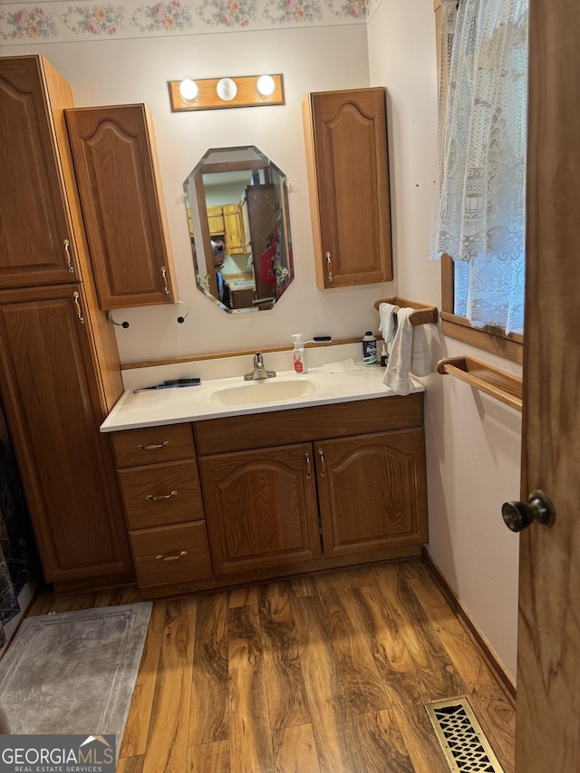bathroom with vanity, visible vents, and wood finished floors