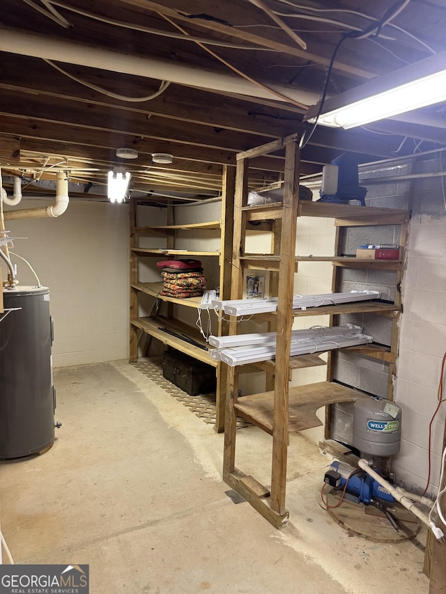 unfinished below grade area with water heater and concrete block wall