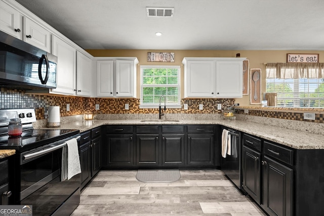 kitchen with dark cabinetry, visible vents, appliances with stainless steel finishes, and a sink