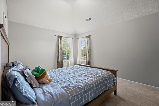 bedroom featuring vaulted ceiling, carpet, visible vents, and baseboards