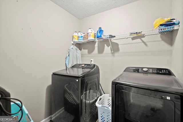 laundry area featuring laundry area, a textured ceiling, and separate washer and dryer