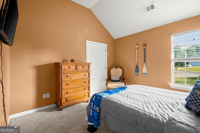 carpeted bedroom with lofted ceiling, baseboards, and visible vents