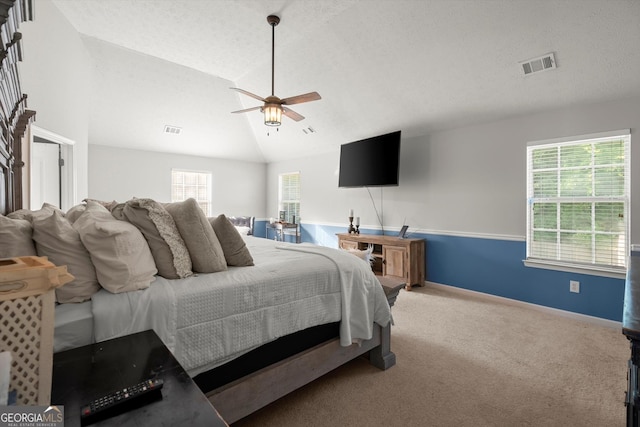 bedroom with ceiling fan, visible vents, carpet, and vaulted ceiling