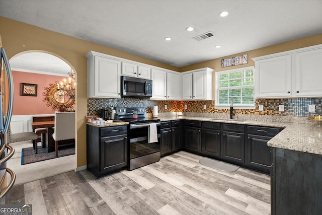 kitchen featuring dark cabinetry, white cabinetry, electric stove, and a sink