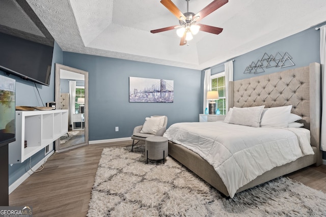 173 Kingswood Dr, Ellenwood, GA 30294 - bedroom featuring baseboards, a tray ceiling, a ceiling fan, and wood finished floors