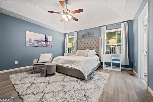 173 Kingswood Dr, Ellenwood, GA 30294 - bedroom featuring baseboards, a raised ceiling, multiple windows, and wood finished floors