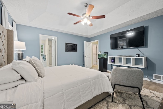 173 Kingswood Dr, Ellenwood, GA 30294 - bedroom featuring wood finished floors, visible vents, a ceiling fan, a tray ceiling, and baseboards