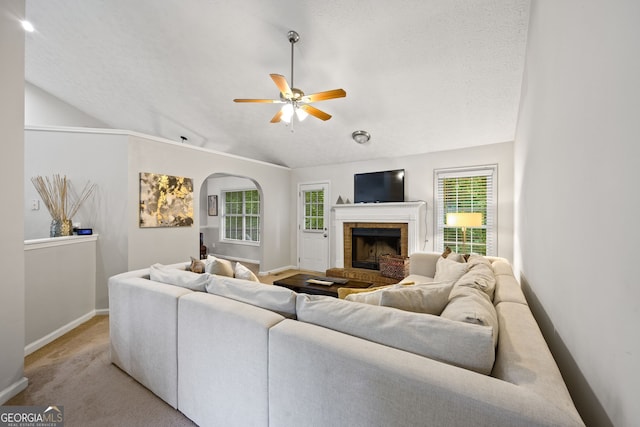 173 Kingswood Dr, Ellenwood, GA 30294 - living area featuring baseboards, ceiling fan, vaulted ceiling, arched walkways, and a fireplace