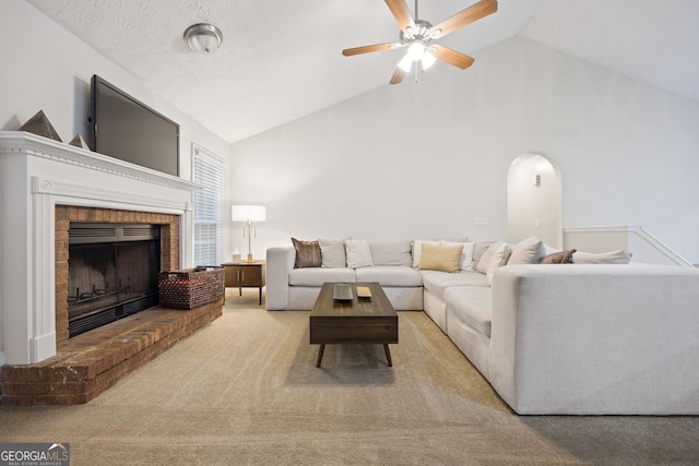 173 Kingswood Dr, Ellenwood, GA 30294 - carpeted living room featuring high vaulted ceiling, a ceiling fan, a brick fireplace, and arched walkways