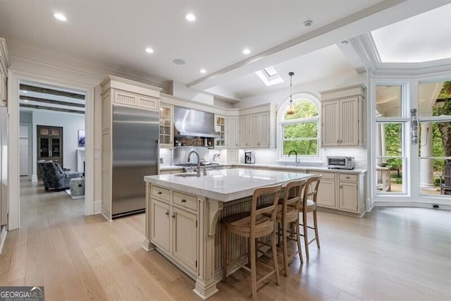 4500 Candacraig, Alpharetta, GA 30022 - kitchen featuring a kitchen island with sink, light wood-type flooring, stainless steel built in refrigerator, backsplash, and wall chimney range hood