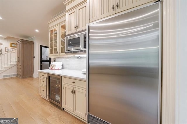 4500 Candacraig, Alpharetta, GA 30022 - kitchen with built in appliances, cream cabinets, light wood-type flooring, light countertops, and beverage cooler
