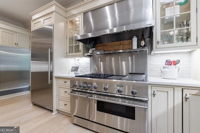 4500 Candacraig, Alpharetta, GA 30022 - kitchen featuring premium appliances, light countertops, wall chimney range hood, and light wood-style flooring