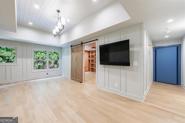 4500 Candacraig, Alpharetta, GA 30022 - unfurnished living room featuring a decorative wall, a barn door, light wood-type flooring, and recessed lighting