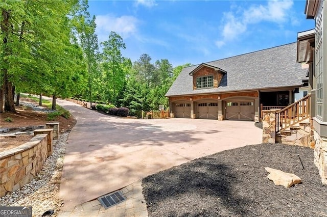 4290 Bobbins Way, Cumming, GA 30041 - view of side of home featuring concrete driveway, roof with shingles, and stone siding
