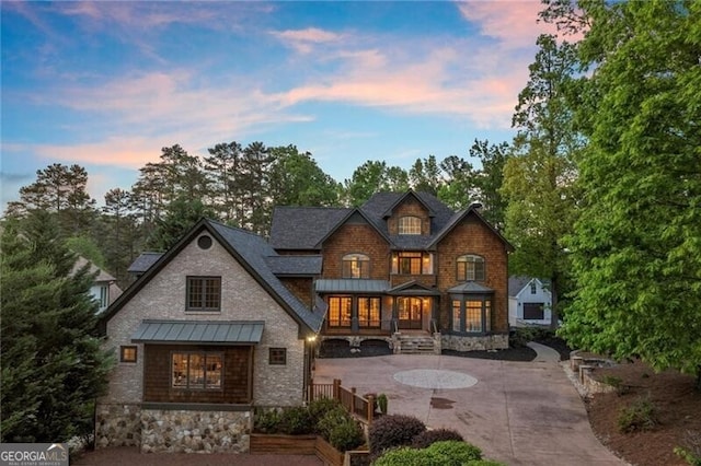 4290 Bobbins Way, Cumming, GA 30041 - back of property at dusk featuring a standing seam roof, curved driveway, and metal roof