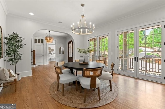 4290 Bobbins Way, Cumming, GA 30041 - dining area featuring arched walkways, a chandelier, french doors, wood finished floors, and ornamental molding