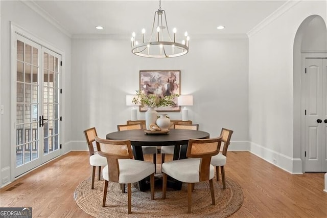 4290 Bobbins Way, Cumming, GA 30041 - dining space featuring arched walkways, a chandelier, light wood-type flooring, baseboards, and ornamental molding