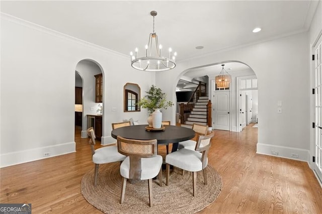 4290 Bobbins Way, Cumming, GA 30041 - dining space featuring a chandelier, arched walkways, stairs, baseboards, and light wood-style floors