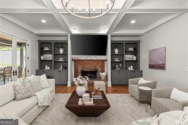 4290 Bobbins Way, Cumming, GA 30041 - living area featuring coffered ceiling, wood finished floors, crown molding, a chandelier, and a stone fireplace