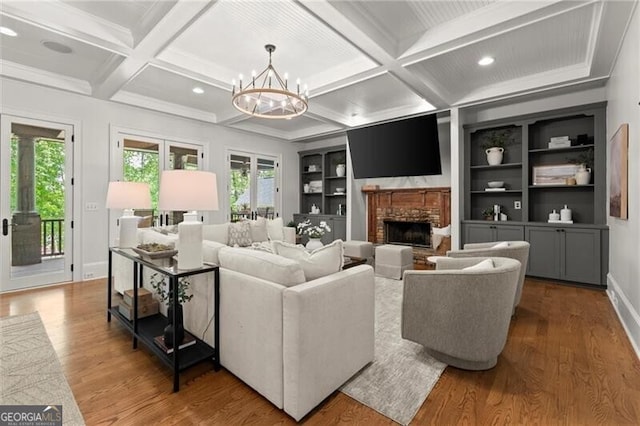 4290 Bobbins Way, Cumming, GA 30041 - living room featuring a fireplace, coffered ceiling, wood finished floors, a chandelier, and beamed ceiling