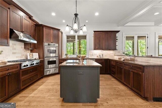 4290 Bobbins Way, Cumming, GA 30041 - kitchen with under cabinet range hood, a sink, stainless steel appliances, light stone countertops, and decorative backsplash