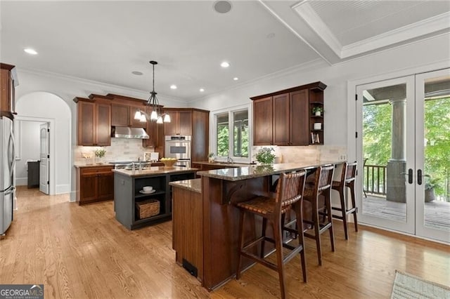 4290 Bobbins Way, Cumming, GA 30041 - kitchen featuring open shelves, french doors, appliances with stainless steel finishes, arched walkways, and under cabinet range hood