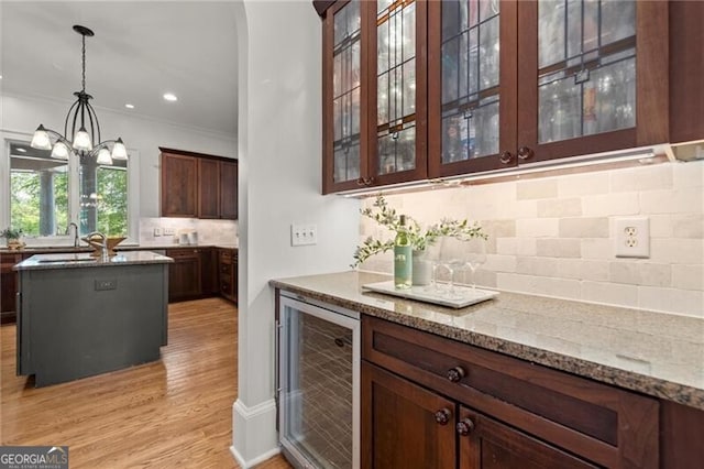 4290 Bobbins Way, Cumming, GA 30041 - bar featuring beverage cooler, backsplash, light wood-style flooring, hanging light fixtures, and a chandelier