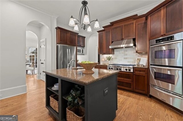 4290 Bobbins Way, Cumming, GA 30041 - kitchen with appliances with stainless steel finishes, under cabinet range hood, arched walkways, a warming drawer, and dark stone countertops