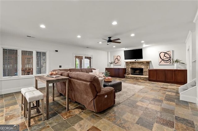 4290 Bobbins Way, Cumming, GA 30041 - living room featuring stone tile flooring, ceiling fan, recessed lighting, a stone fireplace, and ornamental molding