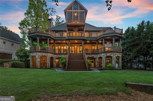 4290 Bobbins Way, Cumming, GA 30041 - back of property at dusk featuring a balcony, stone siding, and stairs