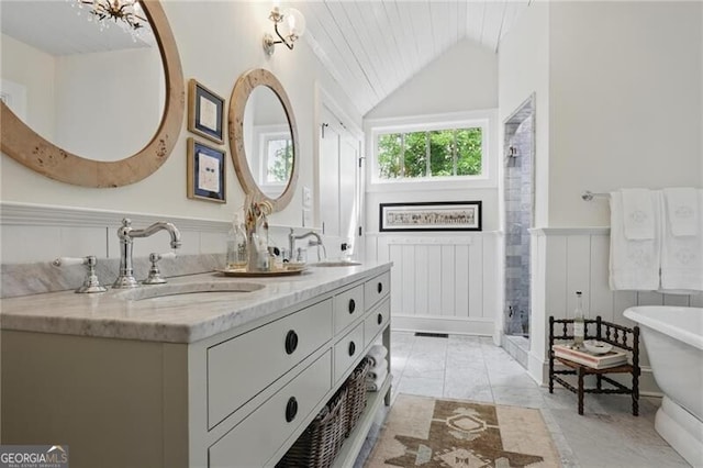 820 Wilson Rd NW, Atlanta, GA 30318 - bathroom featuring a sink, lofted ceiling, a shower stall, and a wainscoted wall