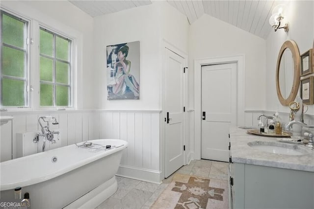 820 Wilson Rd NW, Atlanta, GA 30318 - bathroom with marble finish floor, wainscoting, vanity, a soaking tub, and vaulted ceiling