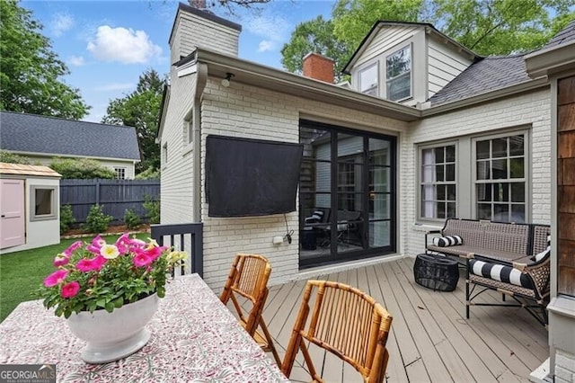 820 Wilson Rd NW, Atlanta, GA 30318 - exterior space featuring a wooden deck, a chimney, brick siding, and an outbuilding