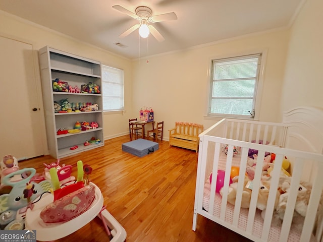 861 Ga Highway 87 N, Cochran, GA 31014 - bedroom featuring wood finished floors, ornamental molding, visible vents, ceiling fan, and a crib