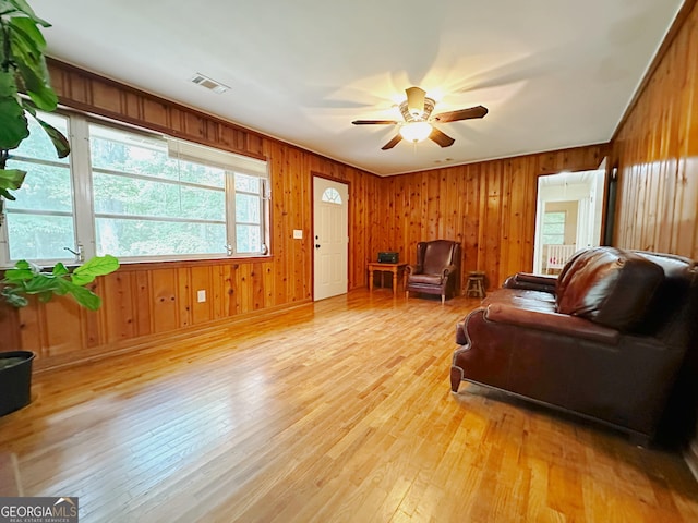 861 Ga Highway 87 N, Cochran, GA 31014 - living room with visible vents, wood walls, light wood-style flooring, and ceiling fan