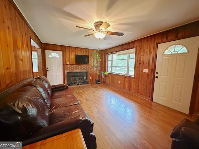 861 Ga Highway 87 N, Cochran, GA 31014 - living room with baseboards, ceiling fan, wooden walls, a brick fireplace, and wood finished floors