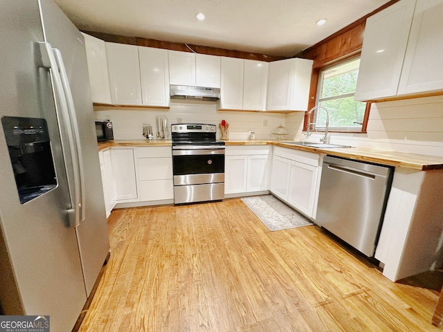 861 Ga Highway 87 N, Cochran, GA 31014 - kitchen with a sink, butcher block countertops, light wood-type flooring, under cabinet range hood, and appliances with stainless steel finishes