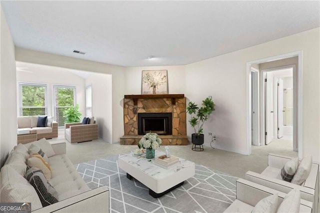 carpeted living room featuring a fireplace and baseboards