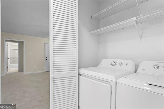 laundry room featuring washing machine and clothes dryer, light colored carpet, and baseboards