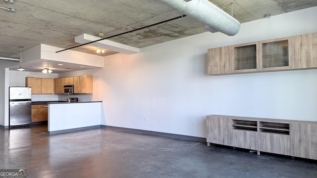 kitchen with finished concrete floors, baseboards, dark countertops, and appliances with stainless steel finishes