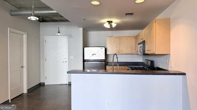 kitchen featuring a peninsula, a sink, dark countertops, stainless steel appliances, and visible vents