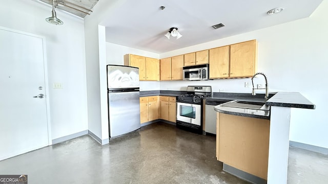 kitchen featuring a sink, a peninsula, visible vents, dark countertops, and appliances with stainless steel finishes
