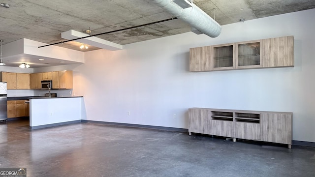 unfurnished living room with concrete floors and baseboards