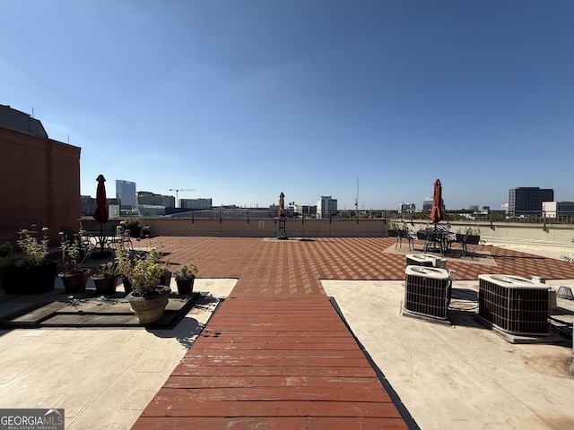wooden terrace with central AC and a view of city