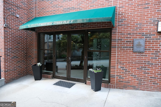 property entrance with brick siding and french doors